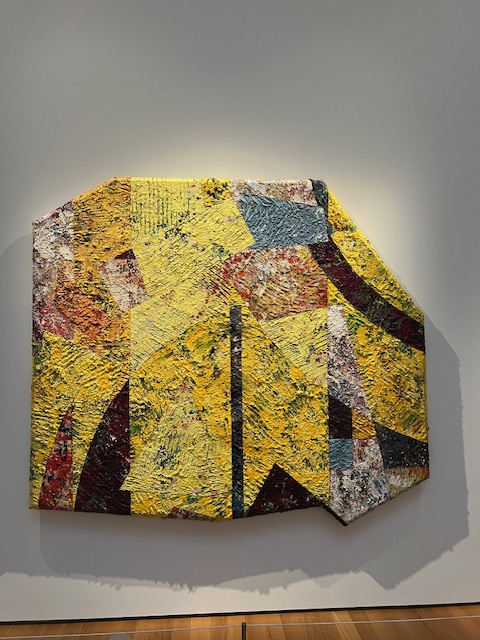 A large abstract painting with bold colors and texture.